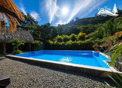 a swimming pool in a resort with a mountain in the background at Cerro Verde Glamping Cartago in Lourdes