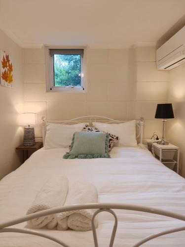 a bedroom with a large white bed with a window at Tranquil Suites in Heart of Leura 3 Minutes to Shops in Leura