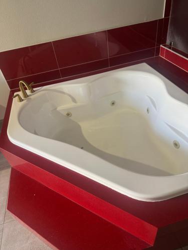 a white bath tub in a red cabinet at Clover motel in Lynwood