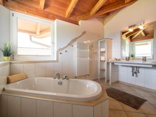 a large white tub in a bathroom with a window at Sonnenwinkel I in Kolsassberg