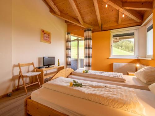 two beds in a room with a desk and a television at Sonnenwinkel I in Kolsassberg