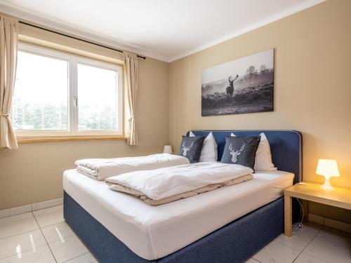 a bedroom with a large bed with a blue headboard at Haslau Large in Hopfgarten im Brixental