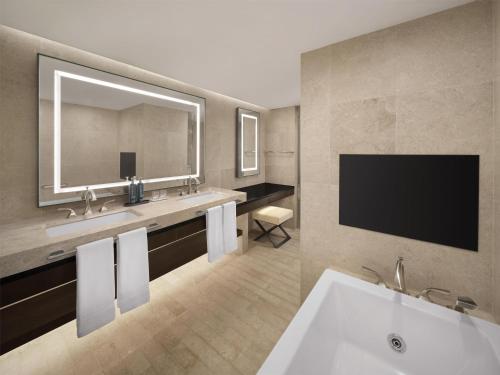a bathroom with a large sink and a large mirror at Hilton Gyeongju in Gyeongju