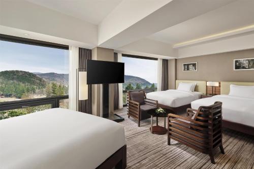 a hotel room with two beds and a large window at Hilton Gyeongju in Gyeongju