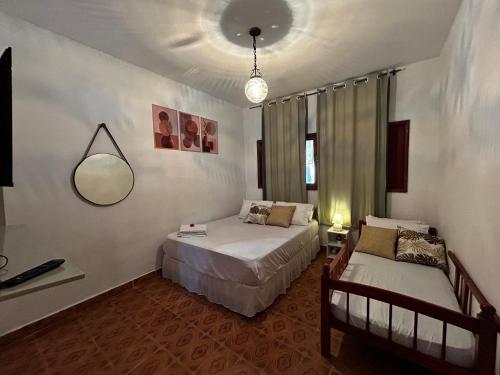 a bedroom with two beds and a mirror on the wall at Chacara c piscina ampla em Pedro de toledo in Pedro de Toledo