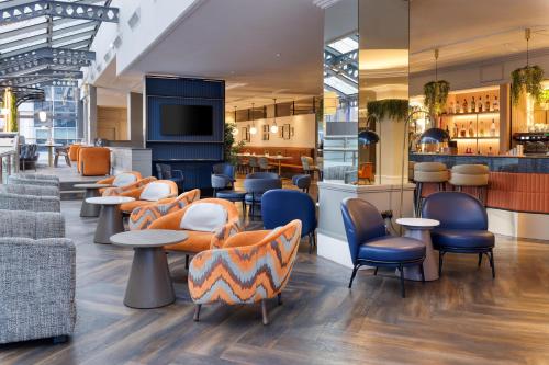 a restaurant with chairs and tables and a bar at Hilton Leeds City in Leeds