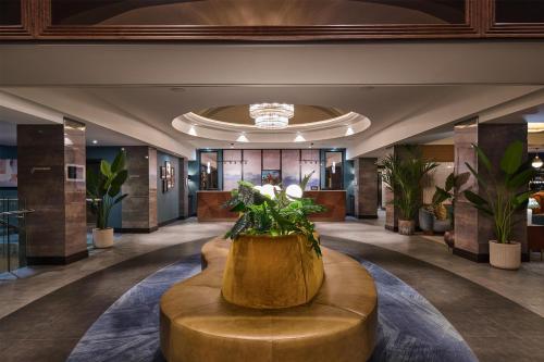 a lobby with a round table and plants at DoubleTree by Hilton London – West End in London