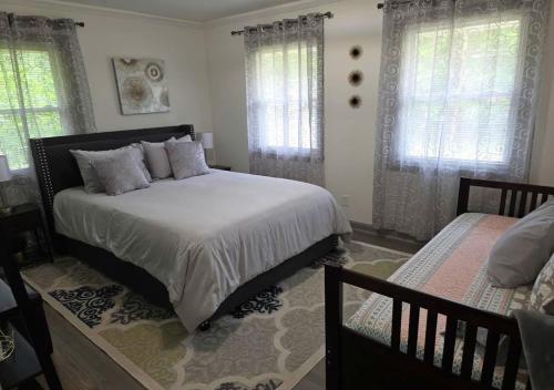 a bedroom with a large bed and two windows at 3BR Home Best of Both-FIFA World Cup-Truist Park in Smyrna