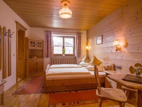 a bedroom with a bed and a desk and a window at Maria Rose XXL in Kirchberg in Tirol