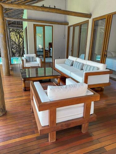 a living room with couches and tables on a wooden floor at Orixás Residence -Casa Yemanja Morro in Cairu