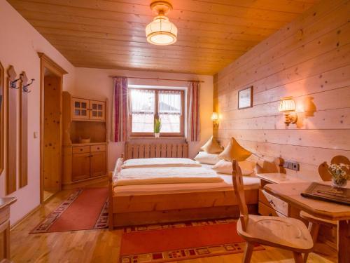 a bedroom with a bed and a desk and a window at Maria Rose XL in Kirchberg in Tirol