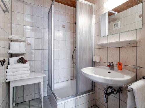 a white bathroom with a sink and a shower at Pension Schreder XL in Kirchberg in Tirol