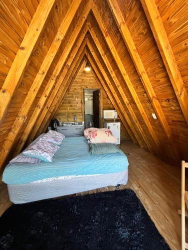 a bedroom with a bed in a log cabin at Pousada Vale das Pedras 03 in Pedras Grandes
