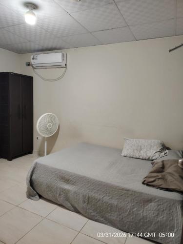 a white bedroom with a bed and a fan at Jadash house in David