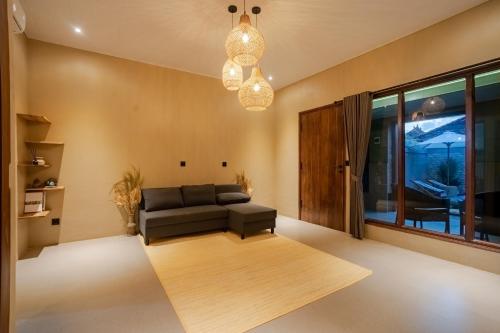 a living room with a couch and a table at Maheeka Villa, Sanur in Sanur