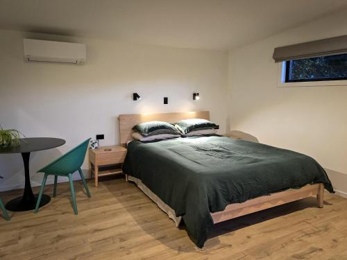 a bedroom with a bed and a table and a chair at Guesthouse on Gardiners in Christchurch