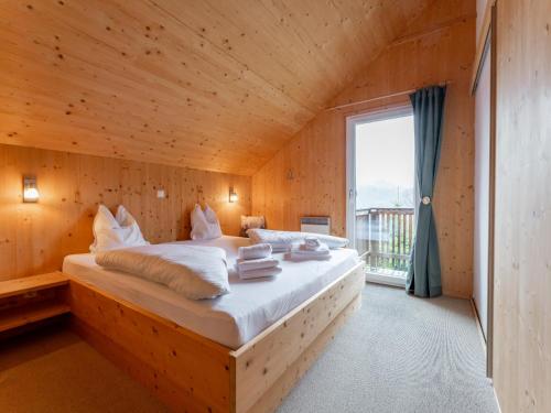 ein Bett in einem Holzzimmer mit Fenster in der Unterkunft Die Bergliebe in Hohentauern