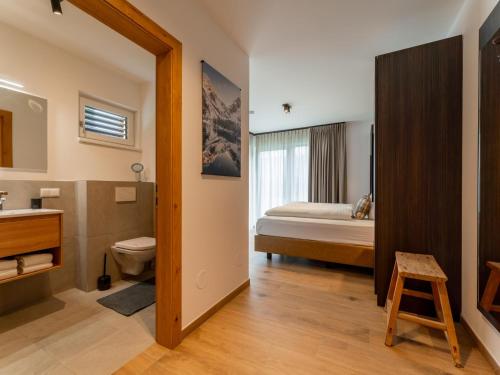 a bathroom with a sink and a toilet and a bed at Grebenzen Lodge Edelblick in Sankt Lambrecht