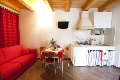 モーディカにあるLe Case Dello Zodiaco albergo diffusoのリビングルーム(赤いソファ、テーブル付)