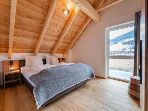 a bedroom with a large bed and a large window at Mountain Chalet Esttes in Sankt Lorenzen ob Murau
