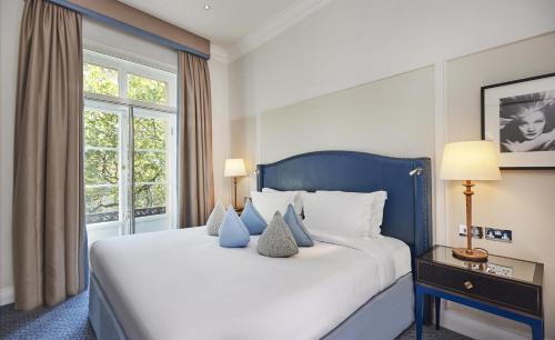 a bedroom with a large white bed and a window at The Waldorf Hilton in London