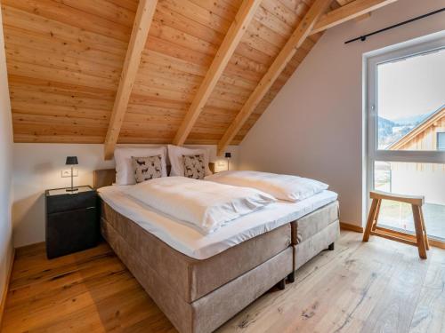a bedroom with a large bed and a large window at Mountain Chalet Berg-Glück in Sankt Lorenzen ob Murau