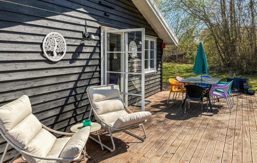 a deck with chairs and a table on a house at Amazing Home In Græsted With Wifi in Græsted