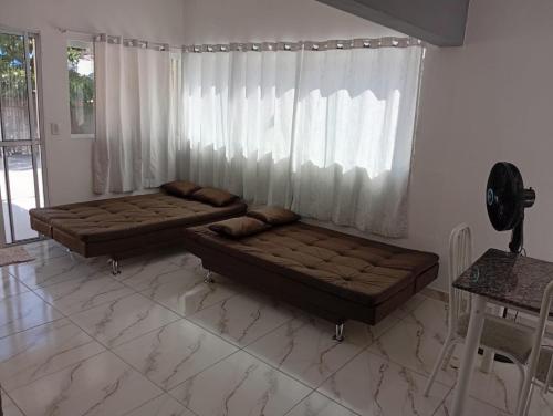 a living room with two beds and a window at Acomodações Souza in Ilhabela