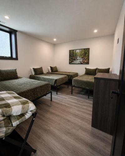 a room with four beds in a room at The Saige - Hot Tub, Fire Pit, and huge entertainment area in Logan