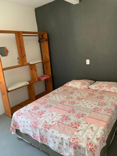 a bedroom with a bed and a book shelf at Apartamento com Terraço na Gamboa do Morro in Cairu