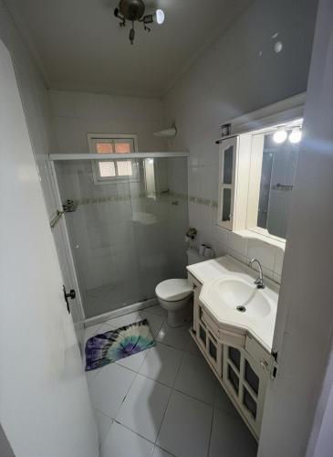 a bathroom with a shower and a toilet and a sink at Casa Shekinah in Araruama