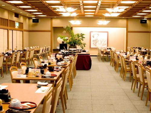a dining room with long tables and chairs at Ryotei Yamanoi in Matsue