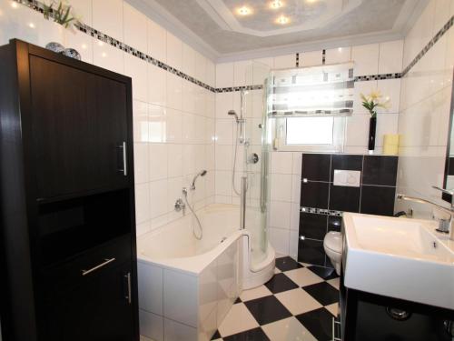 a bathroom with a tub and a sink at Mangartblick in Arriach