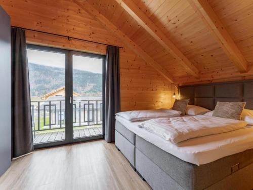 two beds in a room with a large window at Rattendorf 1A in Rattendorf