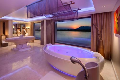 a bathroom with a tub and a sink with a view at Hilton Luxor Resort & Spa in Luxor