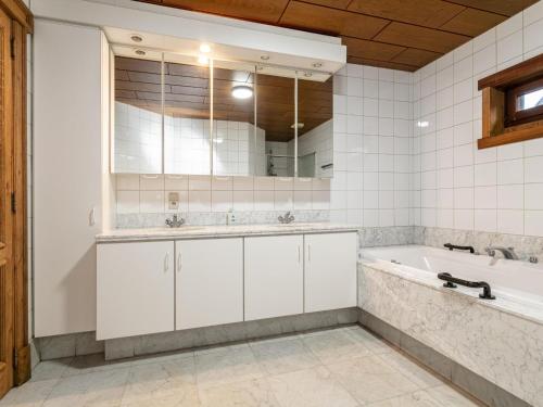 a bathroom with a tub and a large mirror at De Marckhoeve in Merksplas