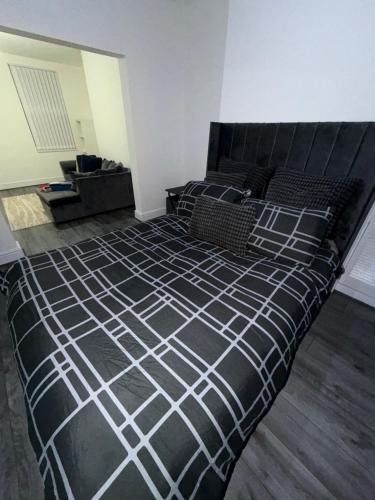 a bedroom with a bed with a black and white comforter at City Home in Liverpool