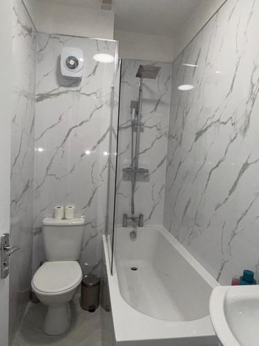 a bathroom with a tub and a toilet and a sink at City Home in Liverpool