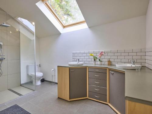 a bathroom with a sink and a toilet and a skylight at Quanto A in Geetbets