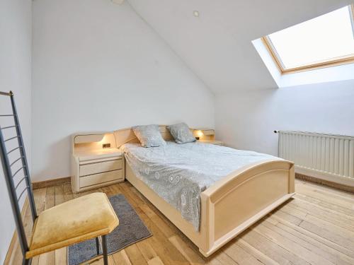 a bedroom with a bed and a chair and a window at Quanto A B in Geetbets