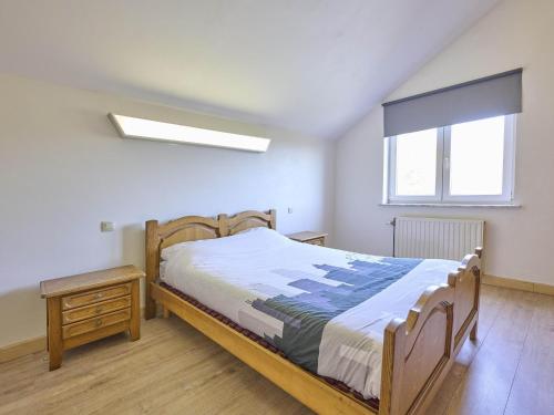 a bedroom with a wooden bed and a window at Quanto B in Geetbets