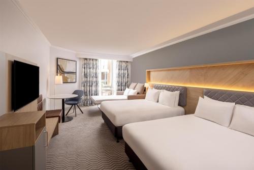 a hotel room with two beds and a television at Hilton Northampton Hotel in Northampton