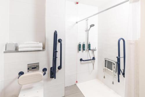 a bathroom with a shower with a toilet and towels at Hilton Northampton Hotel in Northampton