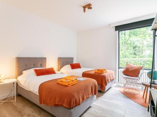 two beds in a room with a window at Maison Clement in Maasmechelen