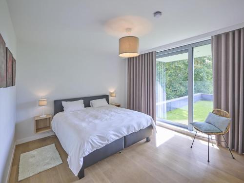 a bedroom with a bed and a large window at Maison Oscar in Tongeren