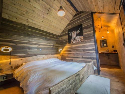 a bedroom with a large bed in a wooden wall at Be Chalet in Ferrières