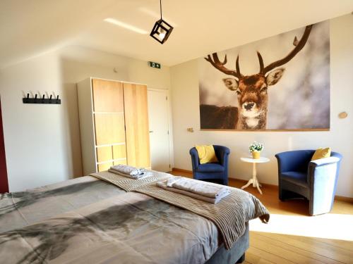 a bedroom with a large painting of a deer on the wall at Villa Belvedère in Houffalize