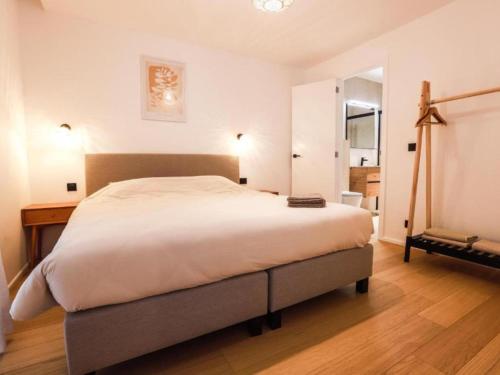 a bedroom with a large bed and a wooden floor at Be Durbuy in Durbuy