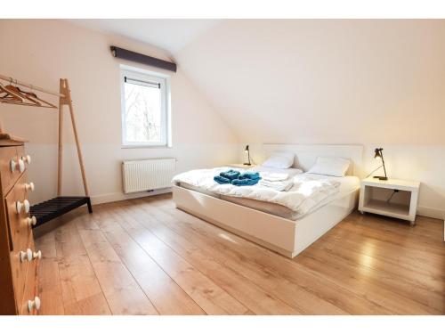 a bedroom with a white bed and a wooden floor at The Green in Durbuy