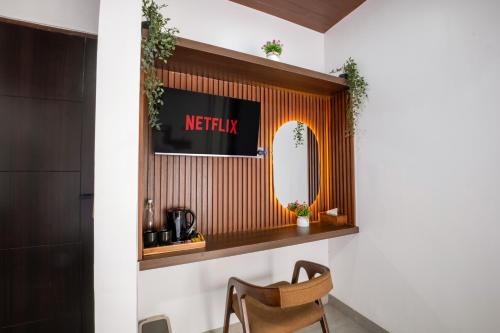 a mirror on a wall in a room with a chair at Gumitish Residence Singaraja in Singaraja